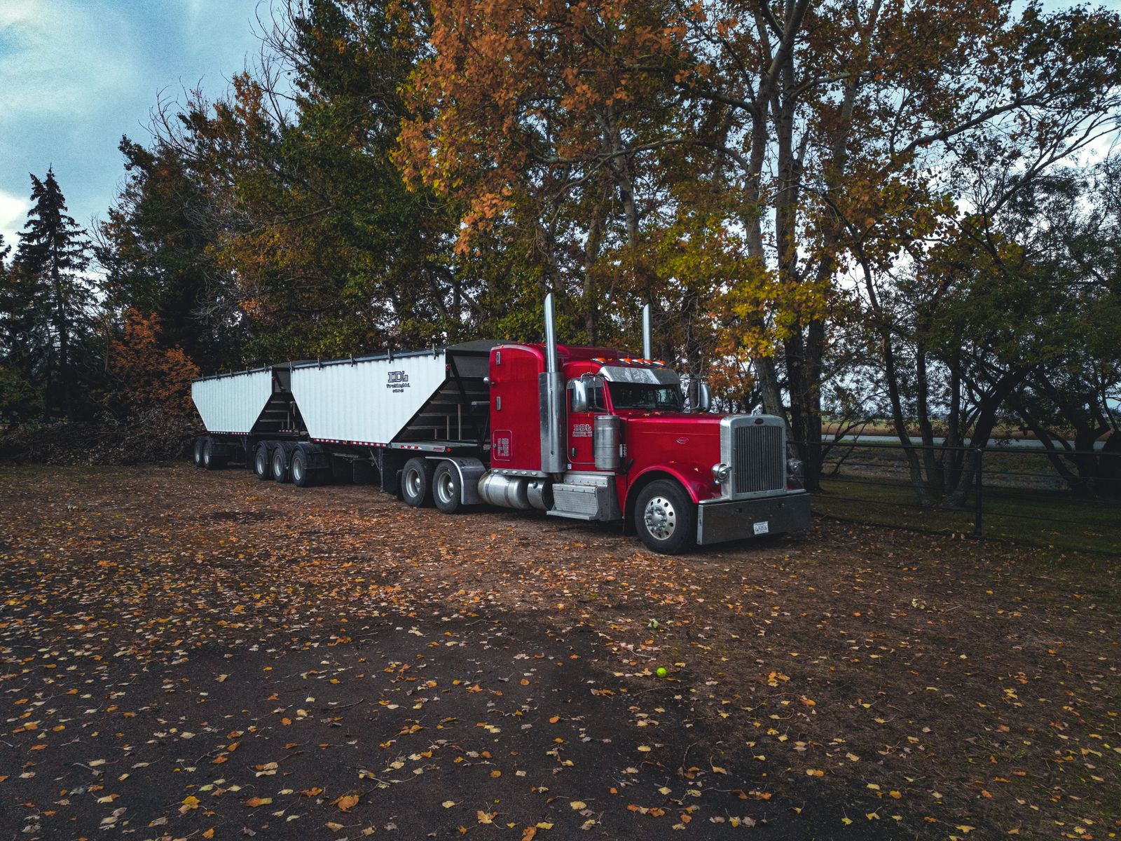 Red Peterbilt semi truck with a hopper trailer