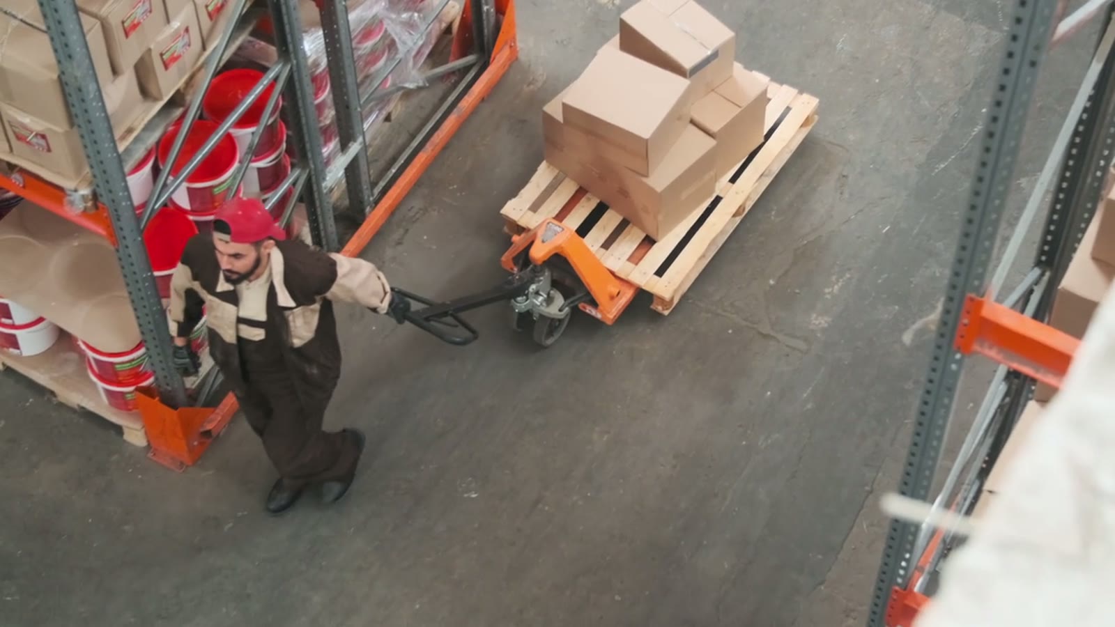 Warehouse worker moving pallets with a pallet jack